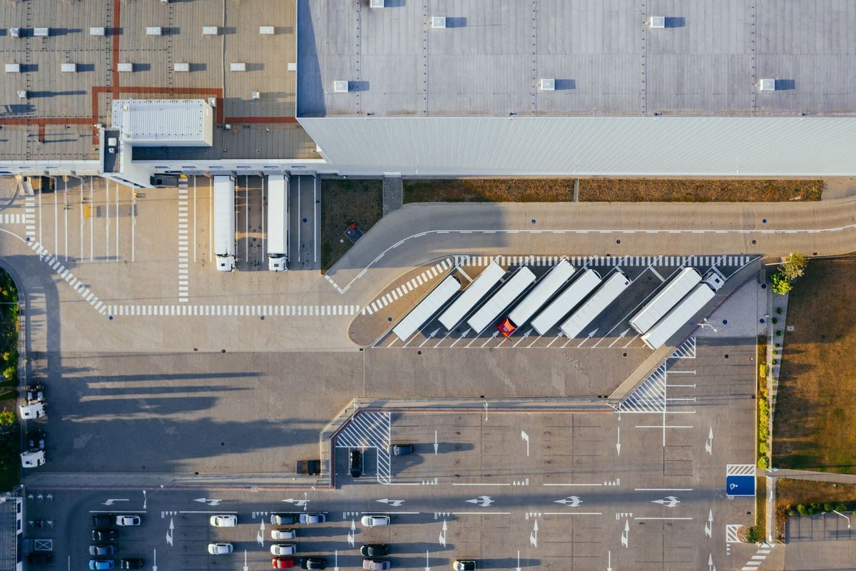 Aerial view of a warehouse complex with fresh line marking across the loading docks, truck bays and car park