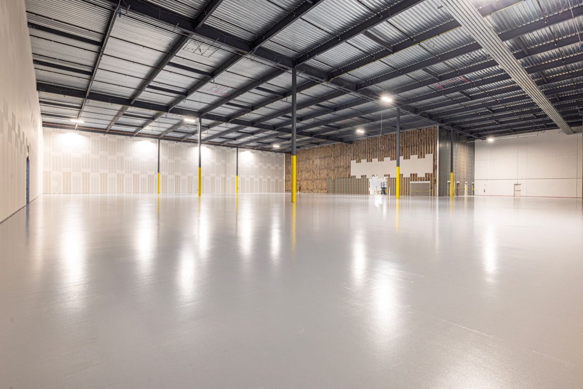 New warehouse with a bare sealed floor, before any line marking